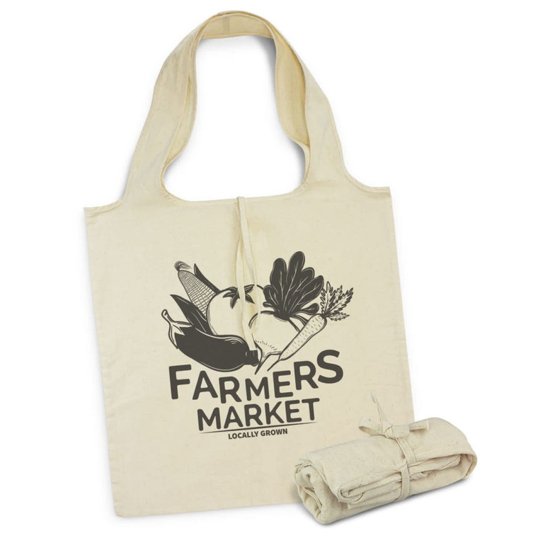 A cream foldaway tote bag with a logo design and matching fabric tie. It features illustrations of vegetables.