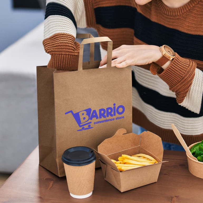 A large flat handle paper bag in brown with a logo, accompanied by a takeaway container and a coffee cup.