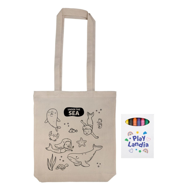 A cream-colored reusable grocery bag with sea-themed illustrations and a set of crayons in a colorful package.
