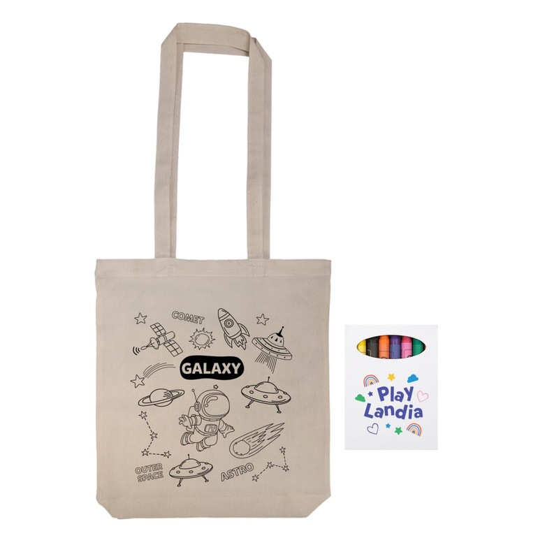 A beige reusable grocery bag with a space-themed design, accompanied by a set of colored crayons in a box.