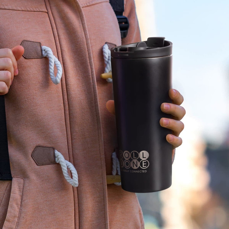 A drink bottle with a sleek black design, featuring a logo, held by a person in a pink hoodie.