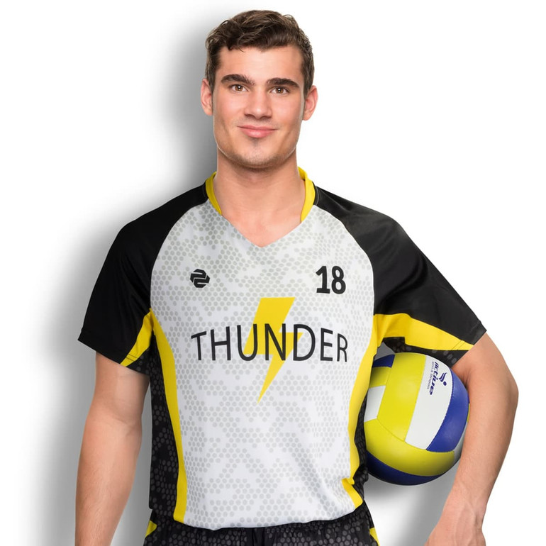 A male model wearing a grey and yellow volleyball top, holding a volleyball and posing against a white background.