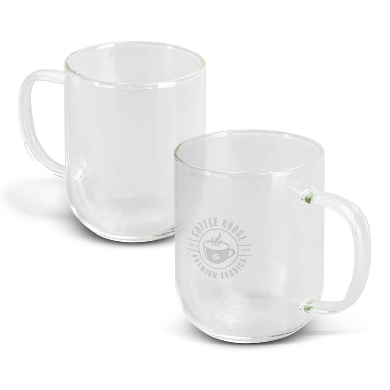A glass mug in clear colour with a handle and a logo on one side. Two mugs are displayed.
