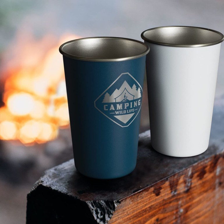 A drink bottle set featuring a blue and a white tumbler, both with a logo, set against a campfire background.