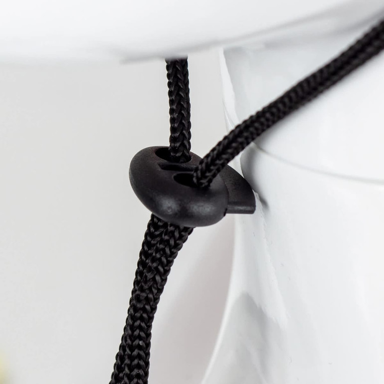 A close-up of a black adjustment toggle on a drawstring, attached to a white hat. The hat features a wide brim.