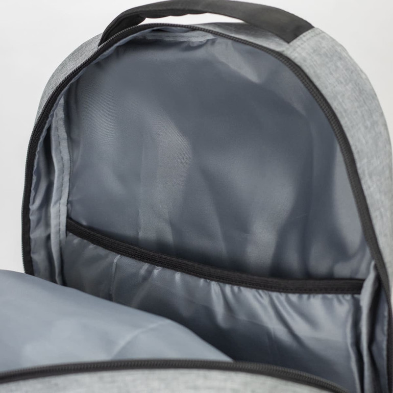 An open grey backpack reveals a spacious interior with a dark grey lining and a storage pocket.