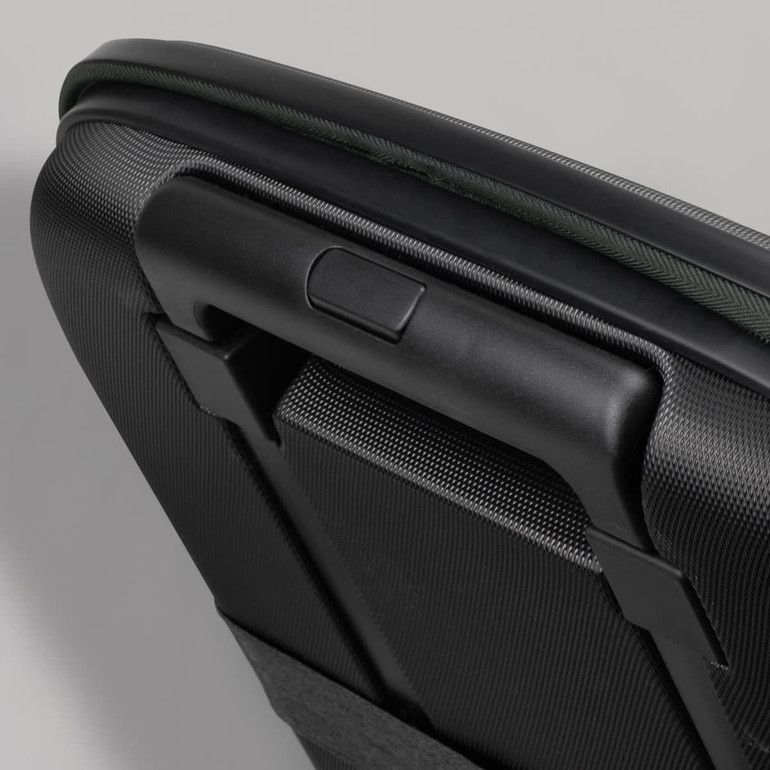 A medium-sized wheeled suitcase with a textured black surface and a green trim, featuring a sturdy handle.