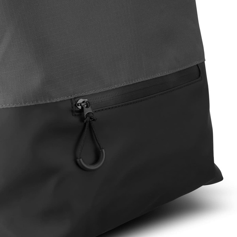 A black backpack featuring a textured grey top and a zipper pocket at the bottom. It has a logo on the side.