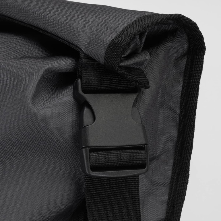 A black backpack with a textured fabric and a sturdy buckle closure. It features a simple design and a logo.