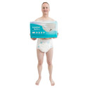 Full body, front view of model wearing BeDry and holding bag of BeDry Premium diapers.