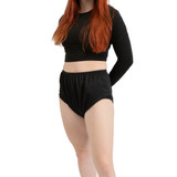 Model with hands behind her back wearing a long sleeve black shirt and black Silence Pants. Model with hands behind her back wearing a long sleeve black shirt and black Silence Pants.