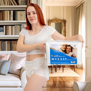 BeDry EliteCare Briefs on female model holding bag of diapers.