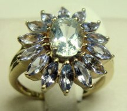 This is a 10 karat yellow gold ring with a tanzanite center stone with aquamarine stone's surrounding it. The total weight of the ring is 5.5 grams and is for a ring size of 8.25