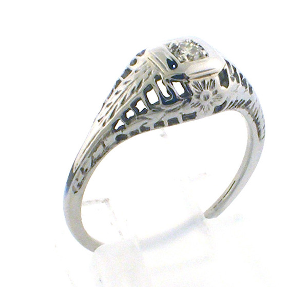 18 karat white gold vintage filligree diamond ring weighing 1.8 grams.  Finger size 6. Diamond is .05ct tw.