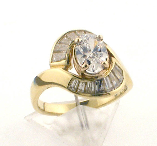 18 karat yellow gold diamond ring.  Baguettes weigh approx .65 ct.  Oval diamond is Lab Created  F VS2 .79ct   IGI Cert 629481924