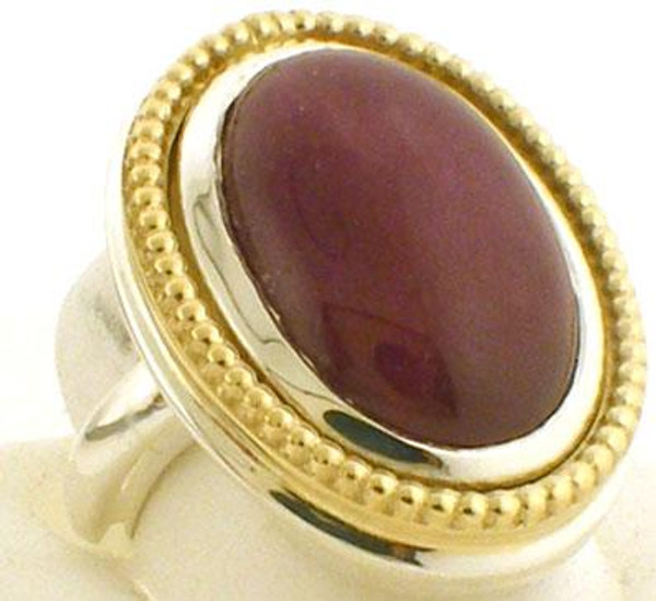 This is a large (27 x 21mm) two tone reconstituted ruby custom made ring.  Ring is sterling silver with a gold beaded frame. Ring is a size 7 and weighs 27.8 grams.