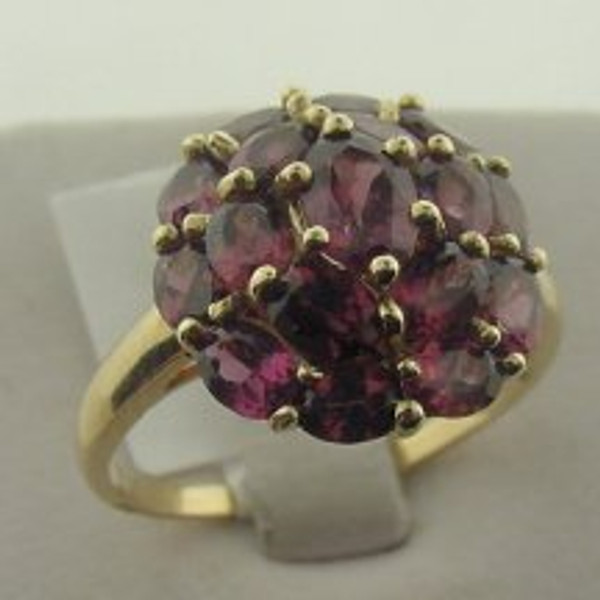 This is a 10 karat yellow gold ring with a rhodalite cluster. The rhodalite TW is 4ct and the ring's total weight is 3.8 grams. The ring was made for a finger size of 10