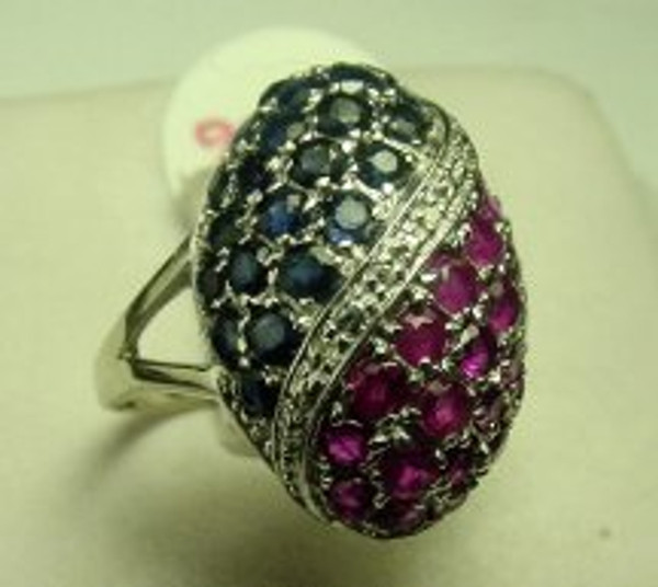 This is a 14 karat white gold ring with a cluster of ruby's, sapphires and diamonds. The total weight of the ring is 5.6 grams and for a finger size of 8.5