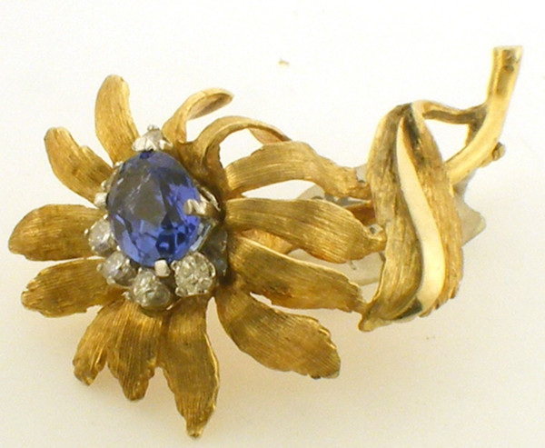 This is a 14 karat yellow gold lapel pin with a 2.5ct tanzanite and six diamonds. The total weight of the diamonds is 0.5ct and the pin has a total weight of 10.6 grams.