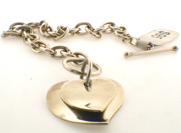 Sterling silver rolo link toggle bracelet with double heart attached. The total length of the bracelet is 7 inches and the total weight is 16.6 grams.