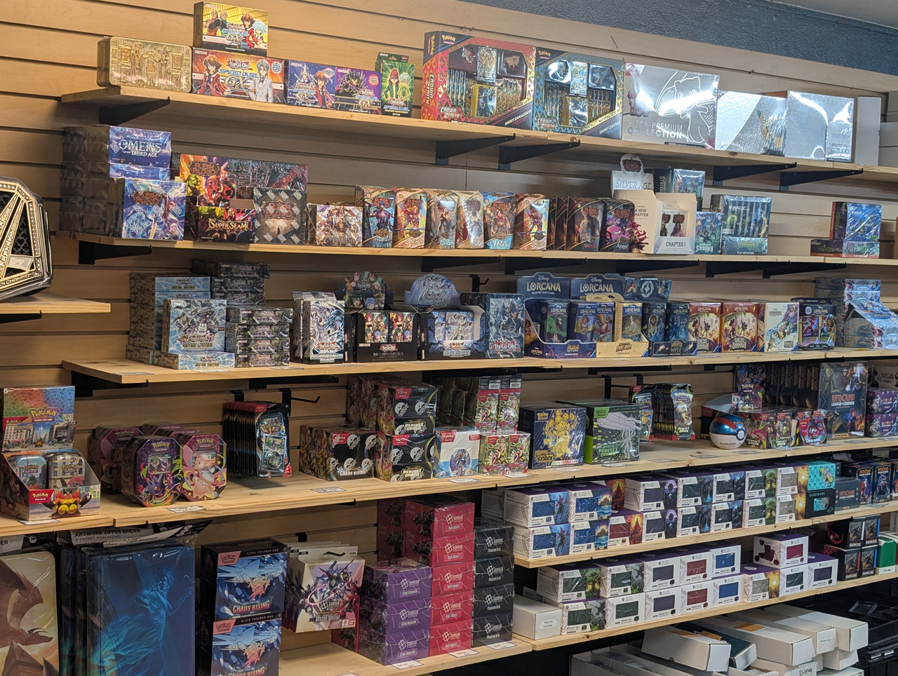 Trading Card Game Products at The People's Card Shop Las Vegas Shelves stocked with Pokémon, Yu-Gi-Oh!, Riftbound, and Lorcana sealed products at The People's Card Shop in Las Vegas