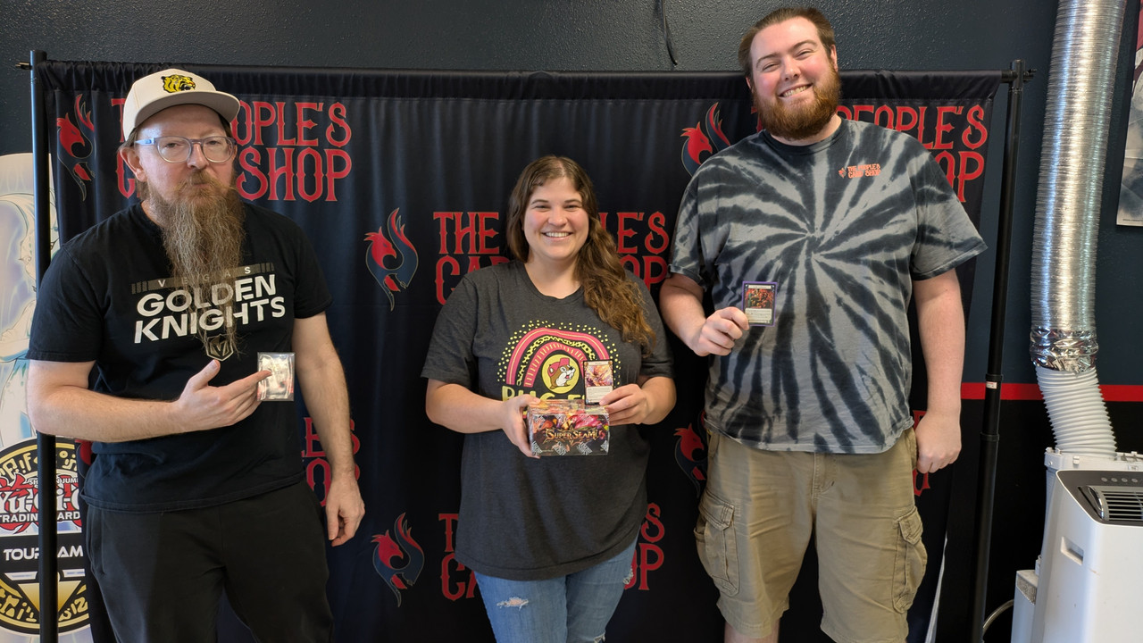 Flesh and Blood Tournament Las Vegas Flesh and Blood tournament winners at The People's Card Shop in Las Vegas holding their prizes