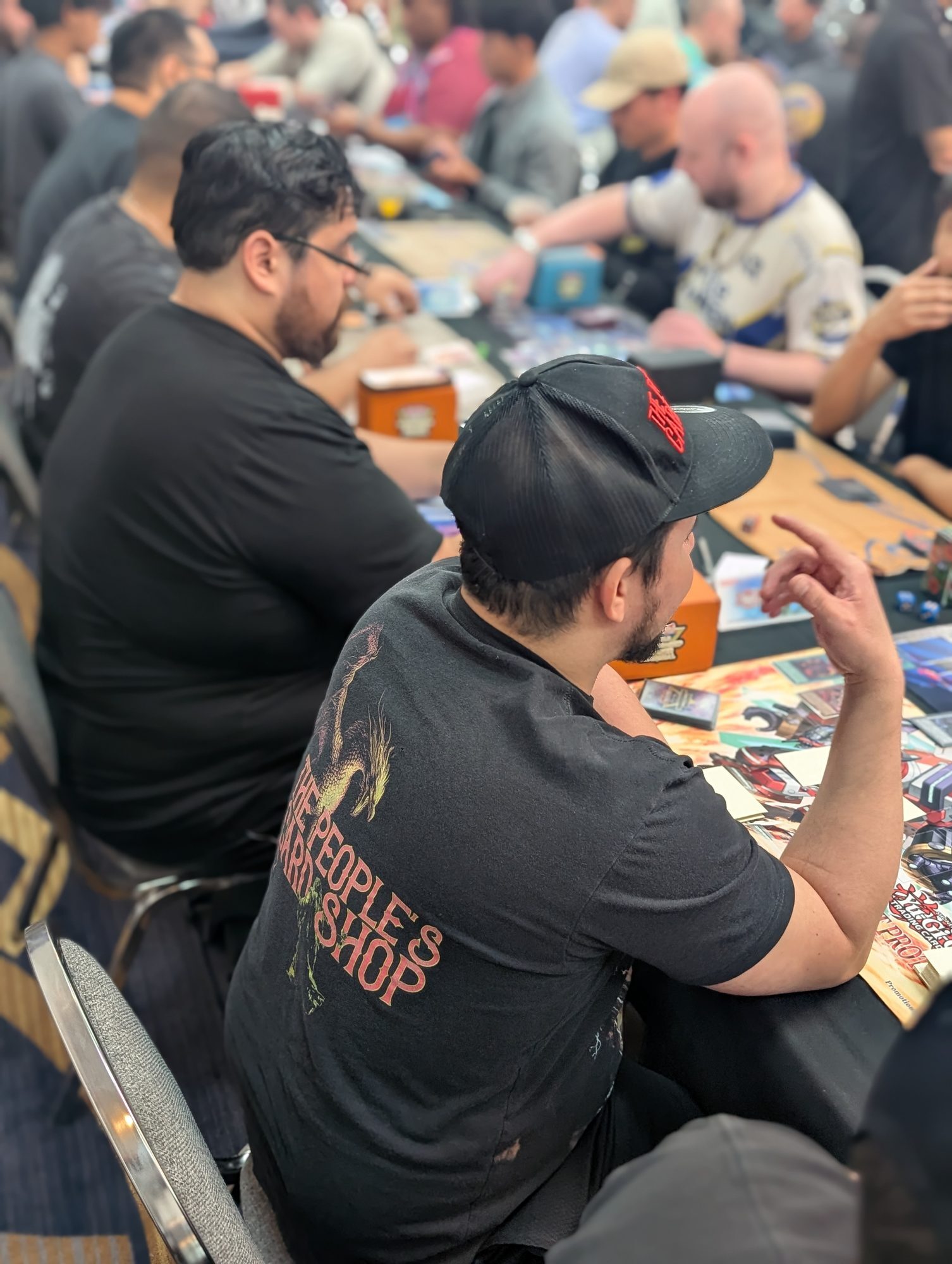 A player in a The People's Card Shop shirt at a Las Vegas Yu-Gi-Oh! Regional