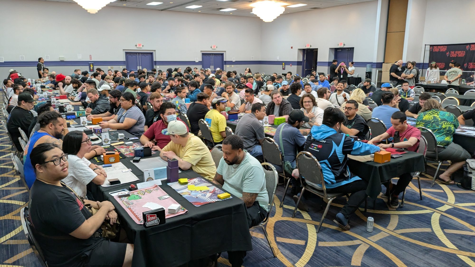 The People's Card Shop banner behind a packed Yu-Gi-Oh! tournament hall in Las Vegas