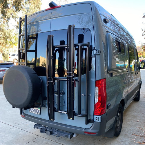 Rear door view of a black Mercedes Sprinter van featuring Aluminess Vertical Bike Rack.