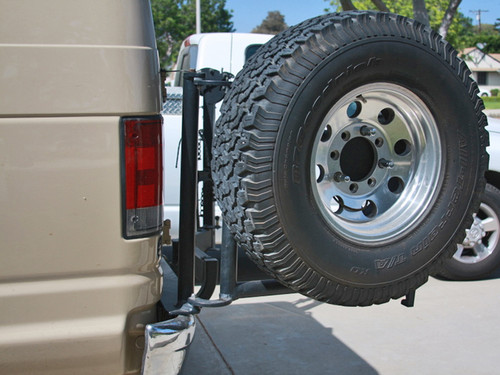Aluminess rear door tire rack on a tan-colored Ford E-Series van.