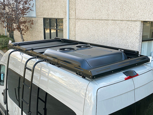 Roof rack crossbar system on a parked white Sprinter van with a rooftop storage box.