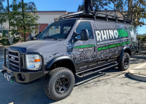 Business logo wrapped Ford E-Series van outfitted with a Weekender Roof Rack from Aluminess Products.