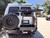 White Ford E-Series van with an off-road rear bumper and swing arm system from Aluminess Products.