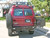 Red Ford E-Series van with an off-road rear bumper and swing arm system from Aluminess Products.