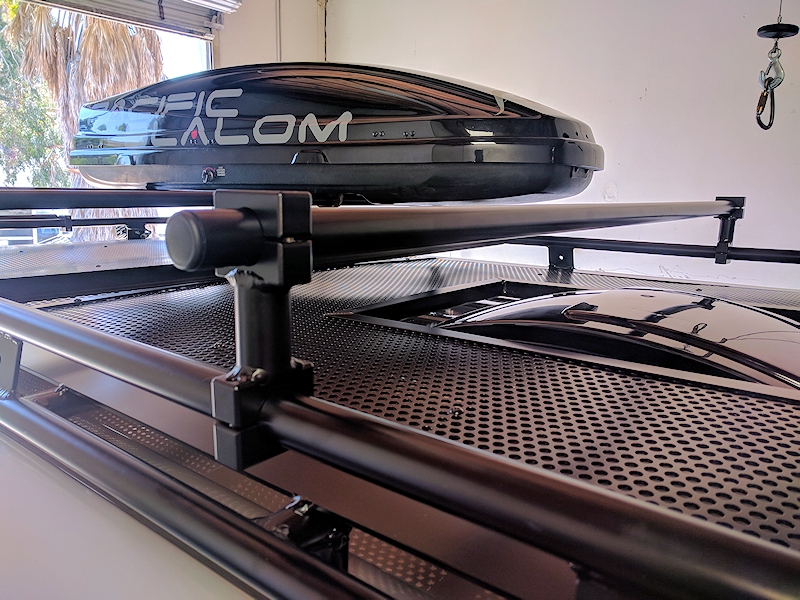 Close-up picture featuring Aluminess Universal Roof Rack Crossbar on top of a van roof rack.