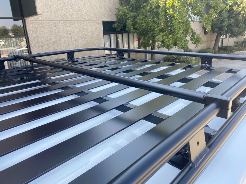 Close-up picture featuring Aluminess Adjustable Telescoping Roof Rack Crossbar on a van roof rack.