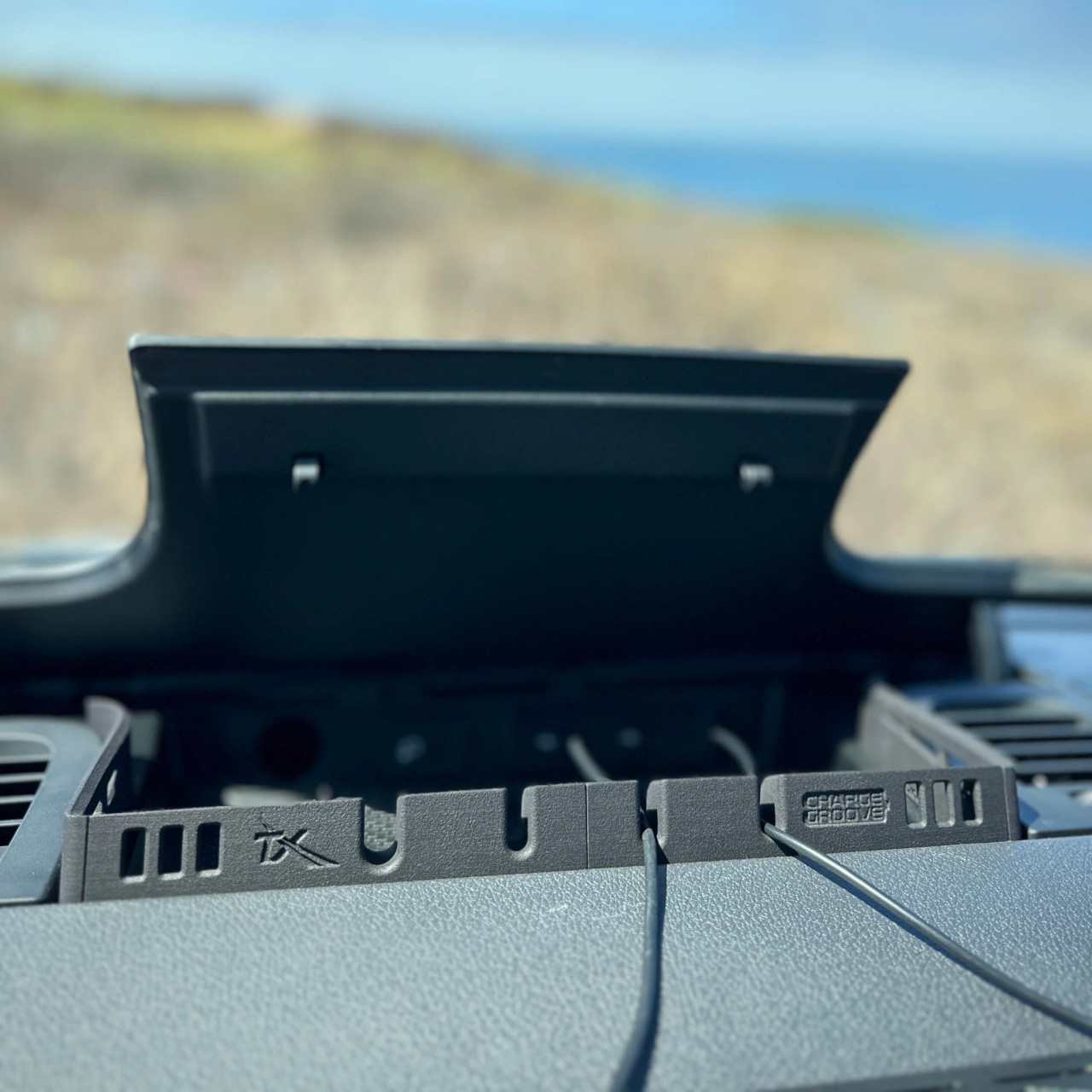 Dash console cable organizer installed on a Sprinter van dashboard.