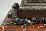 Pendule obélisque en bronze patiné et doré, reposant sur quatre lions antiques