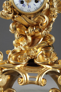 ROCAILLE STYLE CLOCK IN GILDED BRONZE, DECORATED WITH A PUTTO IN A SHELL