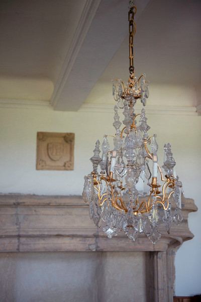 Una lámpara de araña de seis luces en bronce dorado, adornada con colgantes y dagas de cristal tallado
