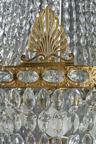 Exquisite light fixture decorated with crystal pendants and gilded bronze details.