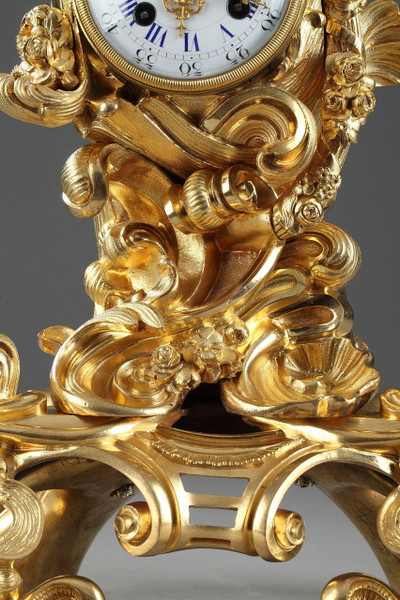 PENDULE DE STYLE ROCAILLE EN BRONZE DORE ORNEE D'UN AMOUR DANS UNE COQUILLE