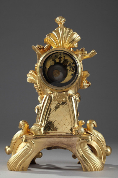 PENDULE DE STYLE ROCAILLE EN BRONZE DORE ORNEE D'UN AMOUR DANS UNE COQUILLE