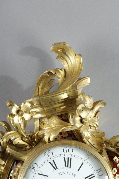 Cartel dapplique à fond rouge et bronze doré.
