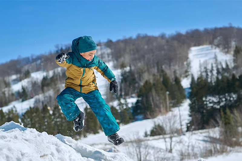 Boy in snow jacket and pants playing outside