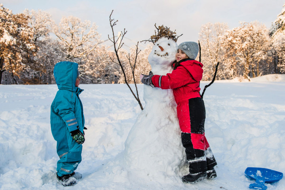 Kids wearing one-piece snowsuits