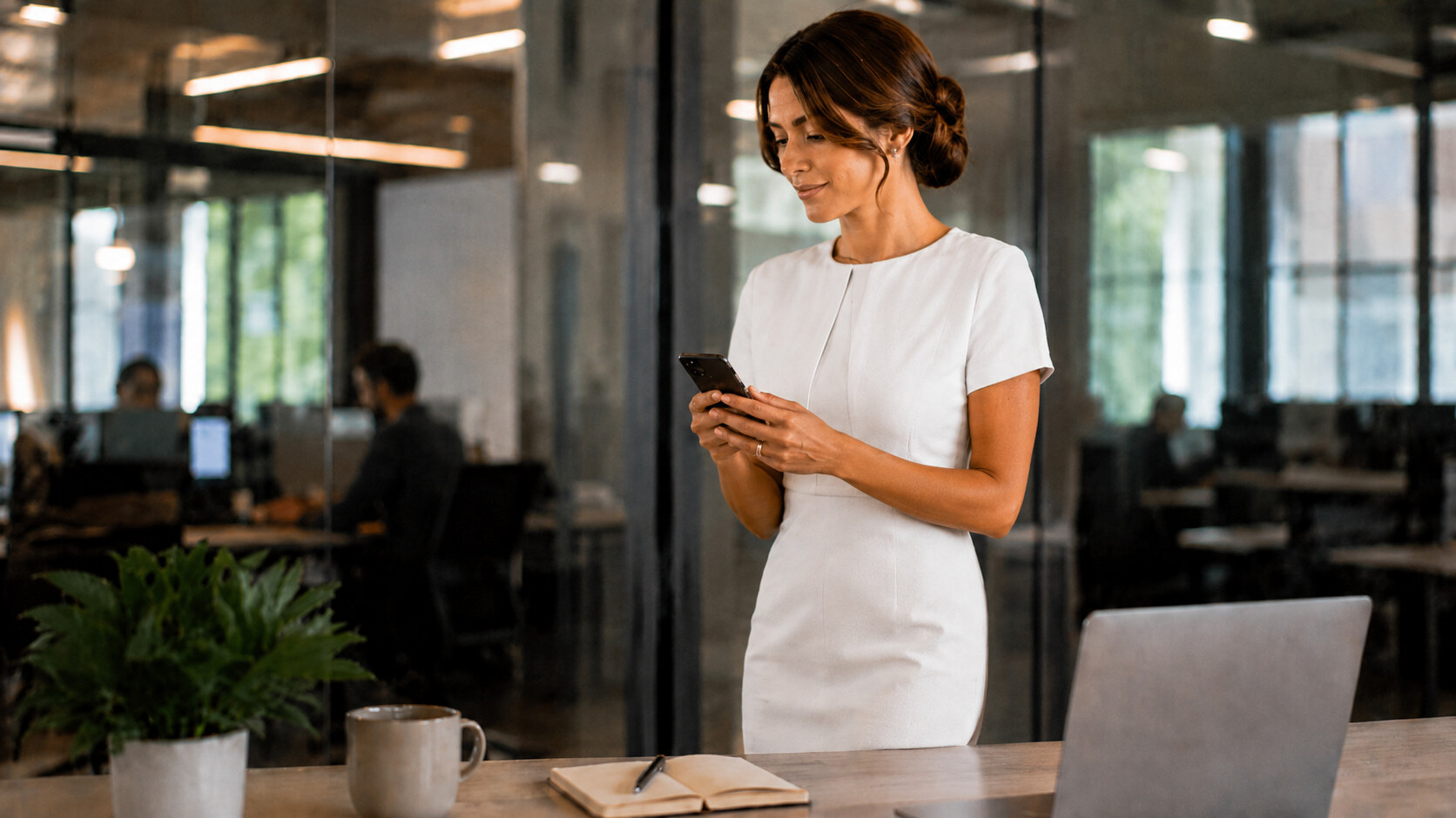 A woman looking at her smart lock app in her modern office.