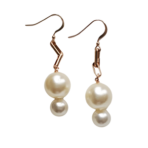 Modern rose gold interlocking link earrings with luminous pearl drops.