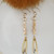 ong gold tassel earrings with brown mother-of-pearl nuggets