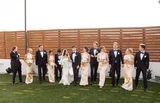 Bride and her bridesmaids in champagne dresses holding white floral bouquets